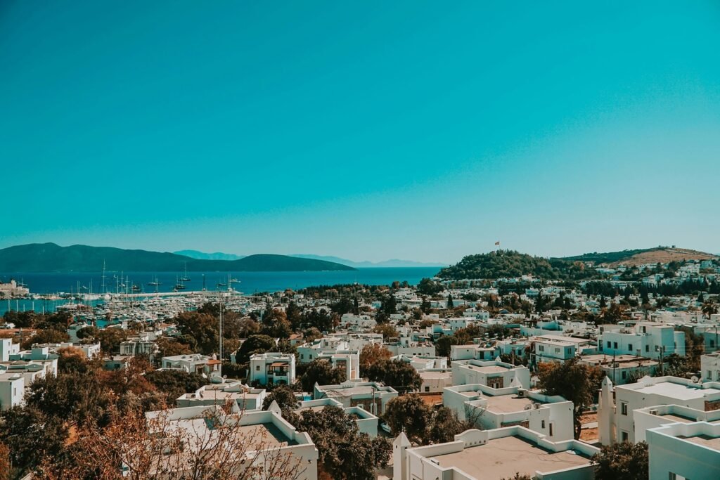 Scenic view of white houses, a marina full of boats, and the turquoise sea in Bodrum.
