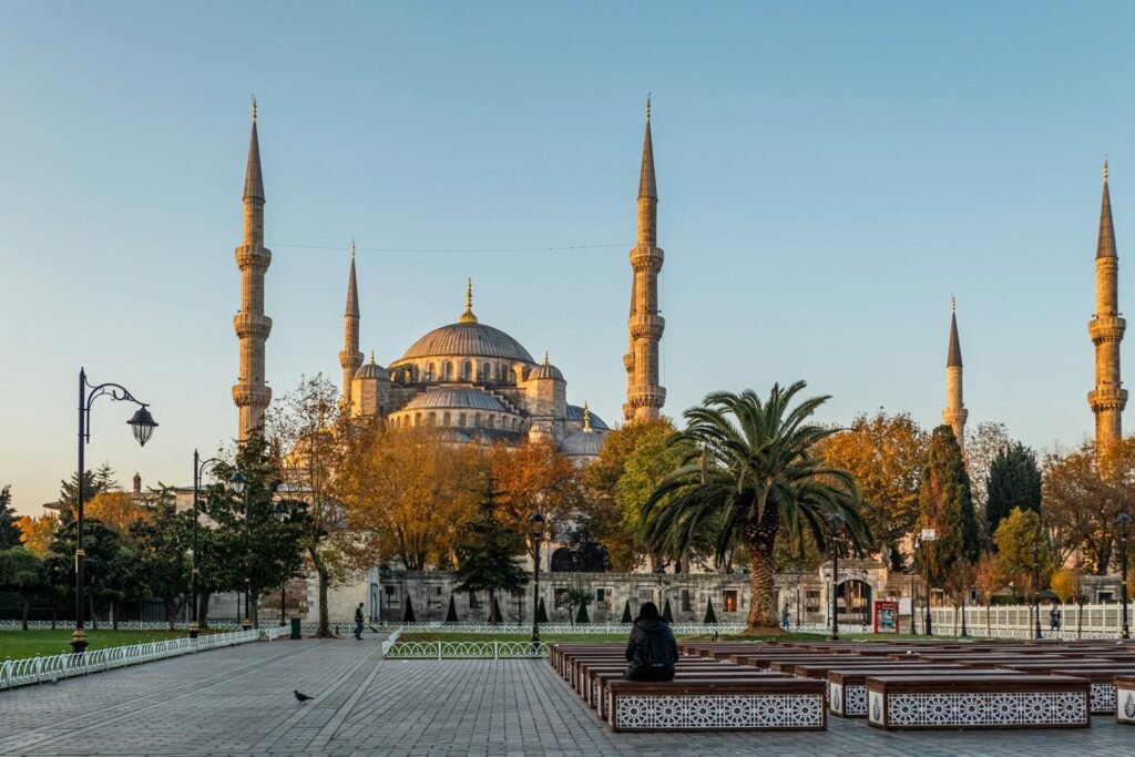 Hagia Sophia, historic mosque in Istanbul with tall minarets, autumn trees, and a peaceful courtyard.